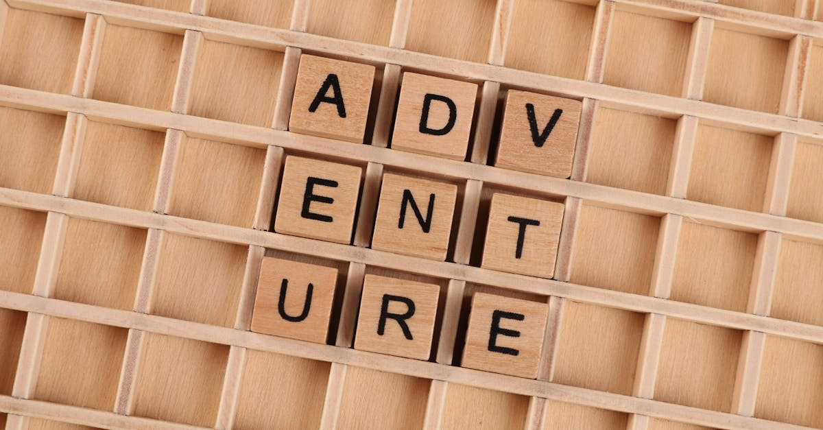 Wooden blocks arranged to spell 'Adventure' on a grid background.