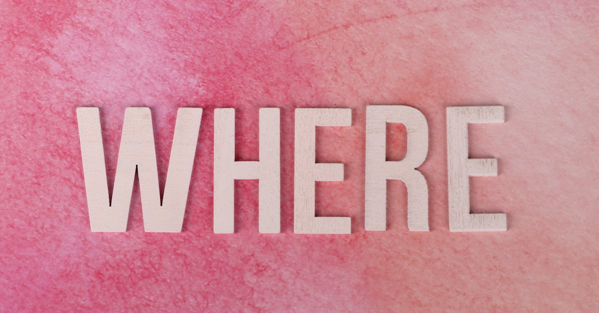 The word WHERE in bold wooden letters on a vibrant pink textured background, offering copyspace.