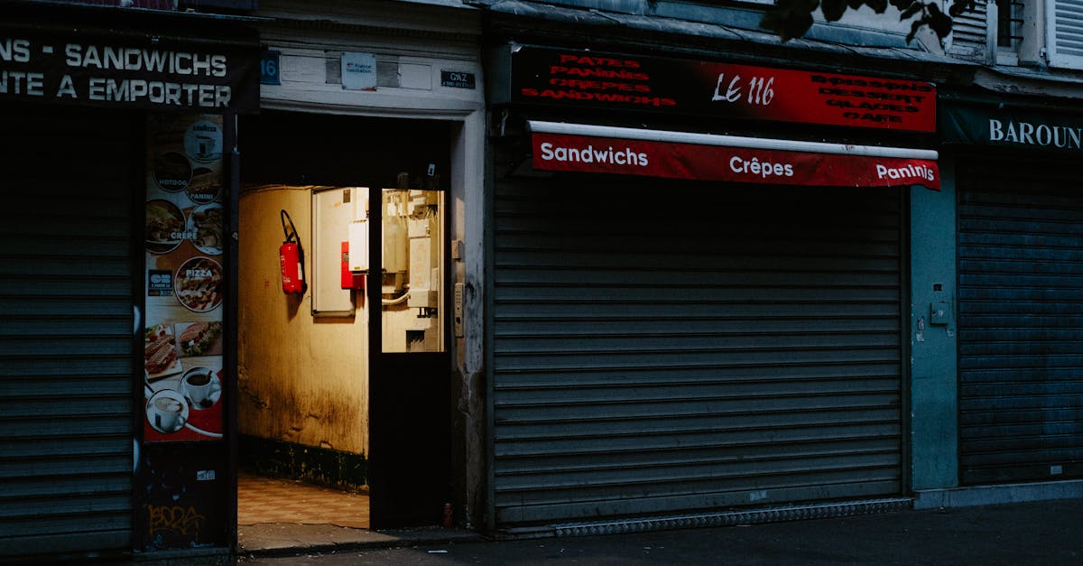 A closed café with a partially open door revealing dim interior lighting, creating a mysterious street scene.