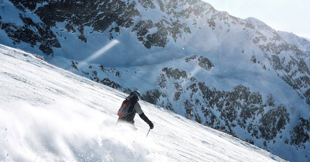 A skier expertly descends a snowy mountain slope in Les Adrets, France.