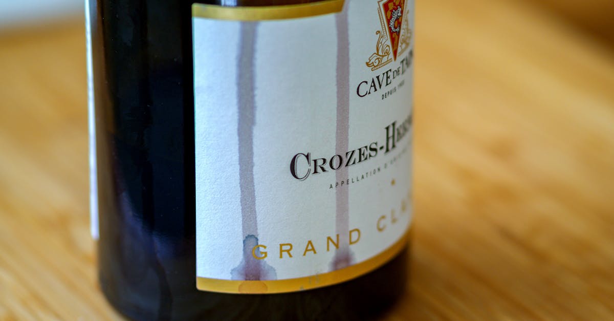 Detailed close-up view of a Crozes-Hermitage wine bottle on a wooden surface.