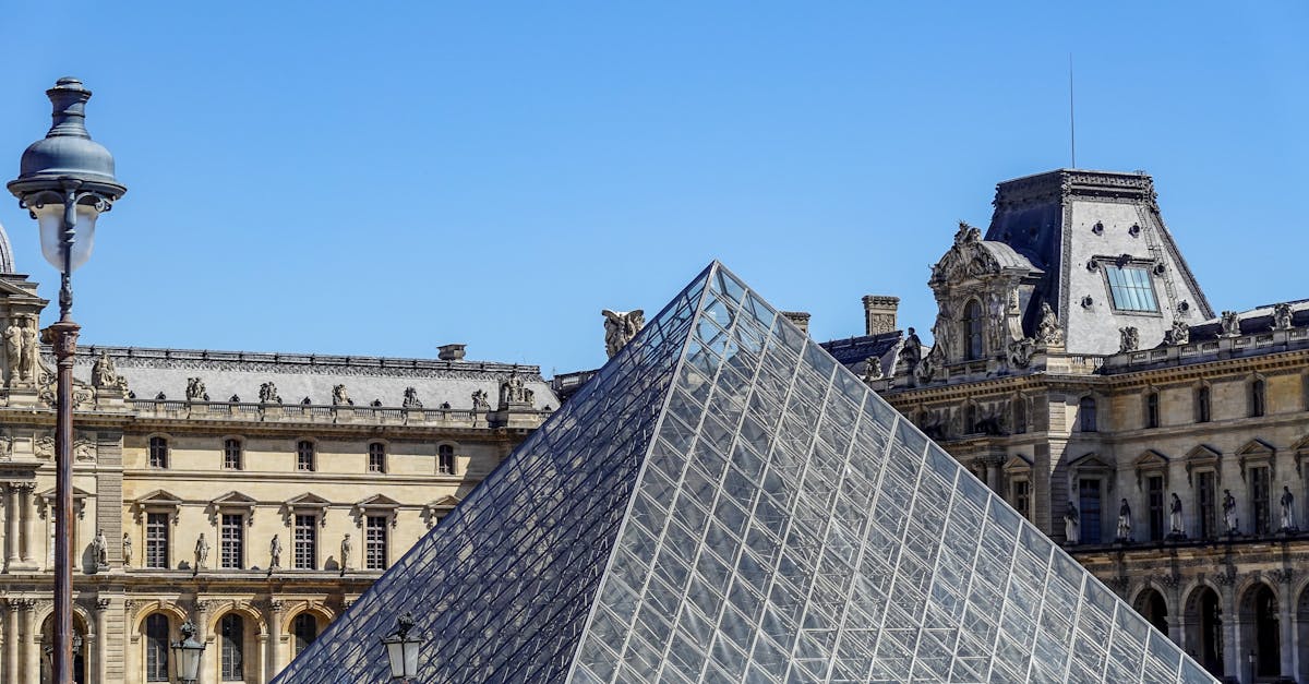 A bustling view of the Louvre Pyramid surrounded by architecture in Paris.