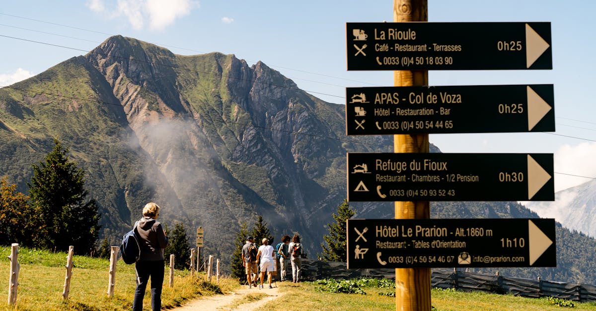 Hikers on a mountain trail with a signpost view at a scenic location.