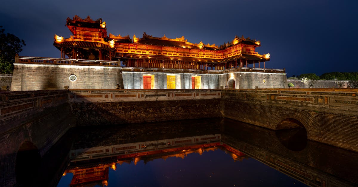 Scenic night view of the Imperial City in Hue with reflections on the water.
