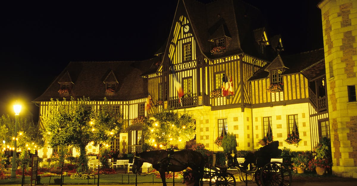 Discover the enchanting night view of Deauville's illuminated gothic-style architecture in Normandie, France.