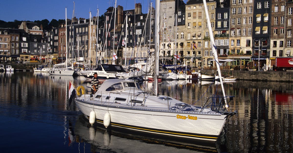 Scenic view of Honfleur harbor in Normandie with yachts and quaint architecture reflecting in the water.