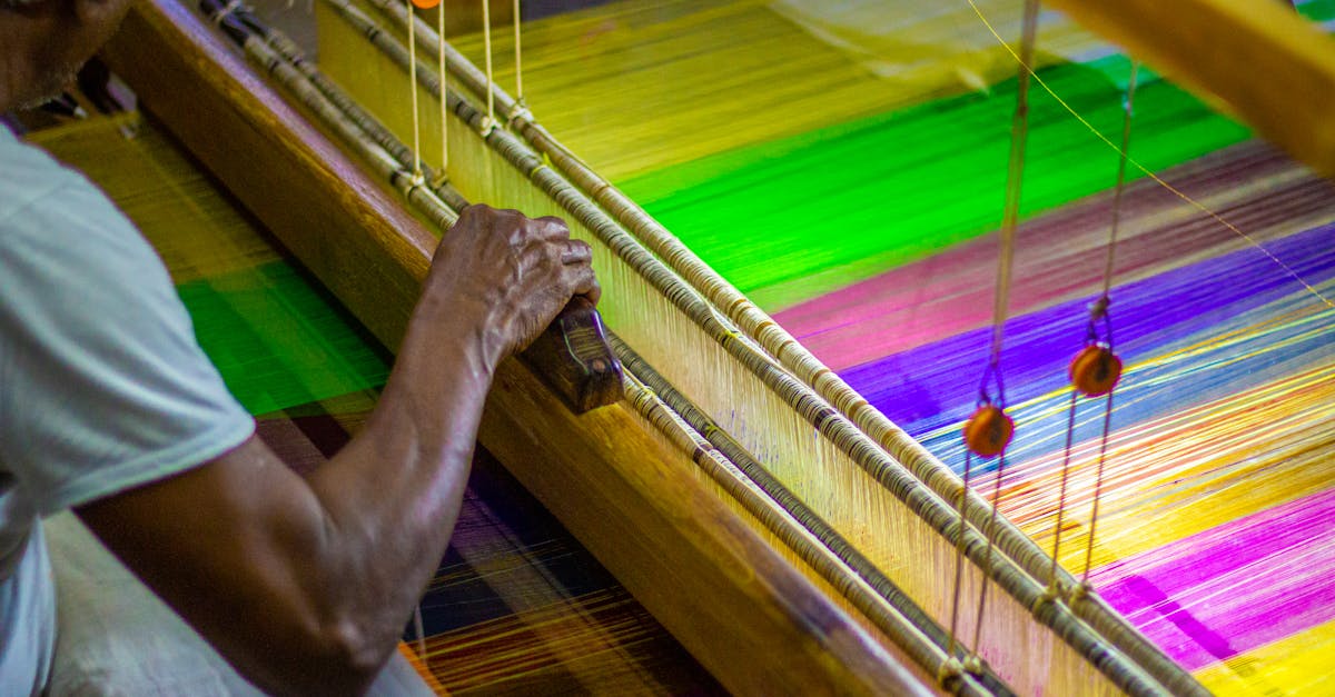 A skilled artisan weaving vibrant silk threads on a traditional loom, showcasing creativity and craftsmanship.