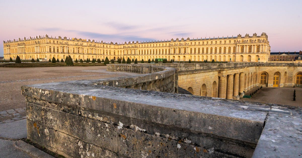 Stunning view of the Palace of Versailles at sunset, highlighting its architectural grandeur.