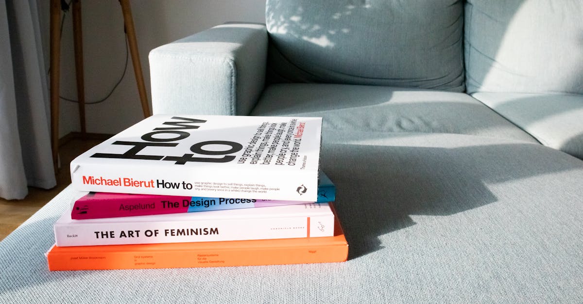 Close-up of design and art books on a modern sofa in a sunlit living room.
