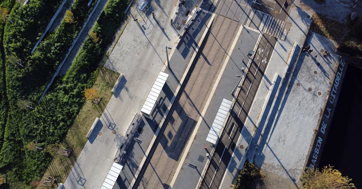 Drone shot of a modern tram station in Strasbourg, showcasing geometric design and lush greenery.