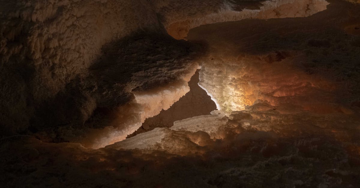 Explore the mysterious beauty of eroded cave formations illuminated by natural light.