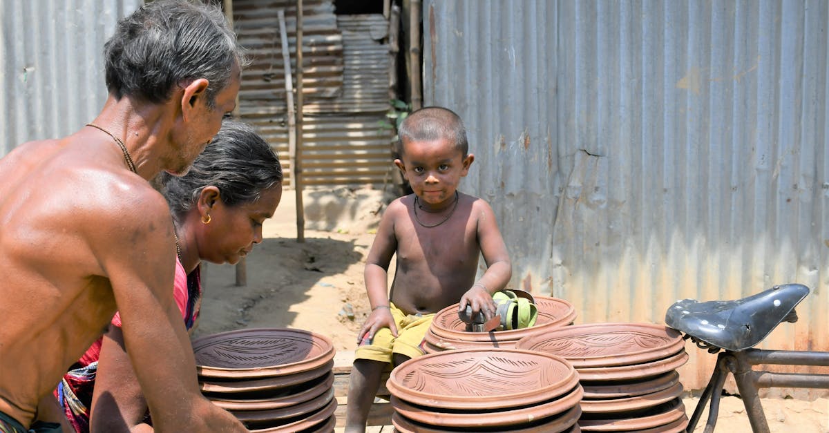 A family collaborates outdoors crafting handmade clay plates on a sunny day.