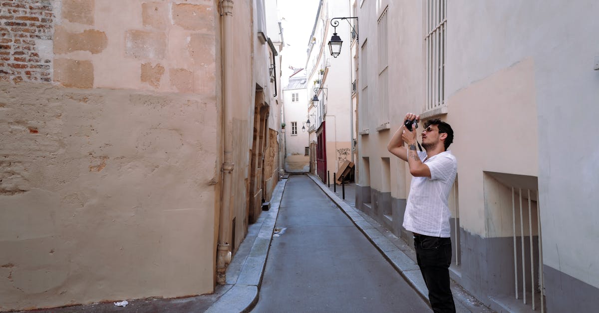 A man captures the charm of an old town's narrow alley, highlighting urban exploration.
