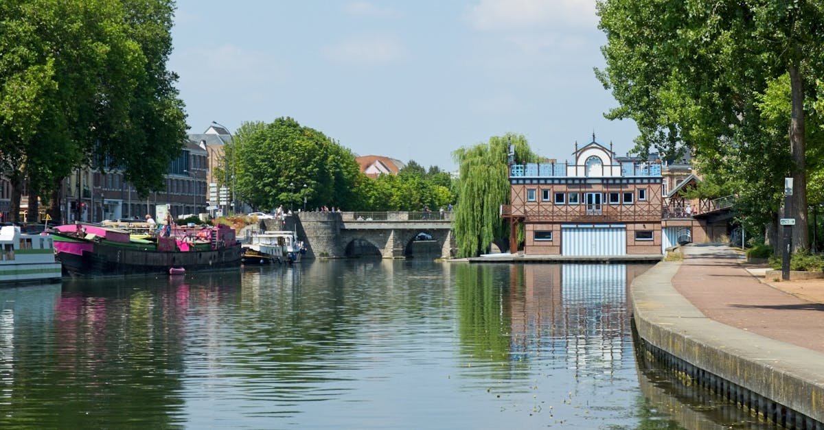 Picturesque canal scene in Amiens, France, featuring historic bridges and reflections on the water.