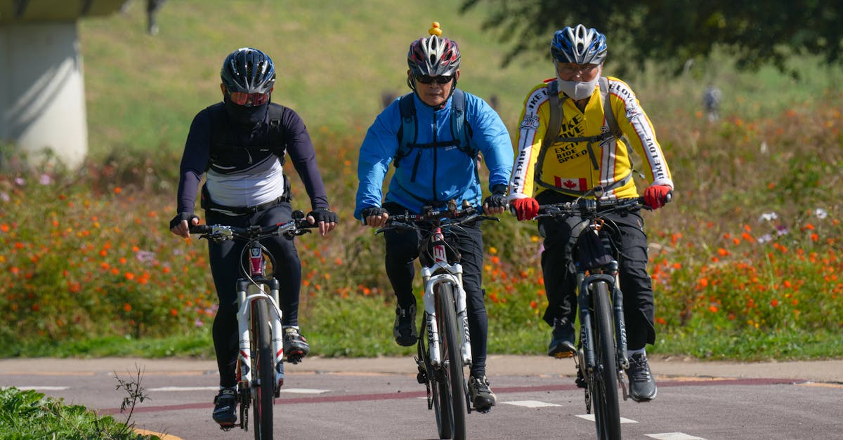Three men cycling with helmets on a sunny day, showcasing outdoor activity and health.