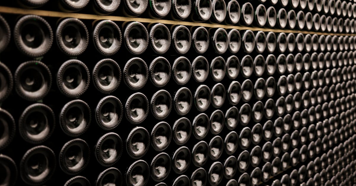 A close-up view of wine bottles stacked symmetrically in a wine cellar in Brussels, Belgium.