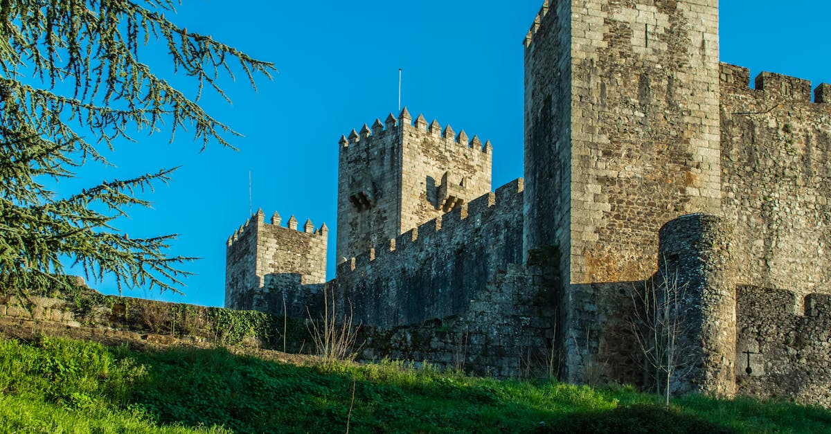Explore the majestic medieval towers of Sabugal Castle in Portugal under a clear blue sky.