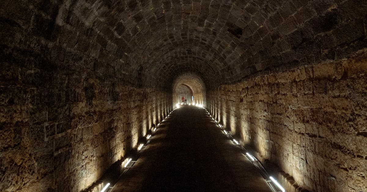 Explore the moody ambience of an illuminated stone tunnel with perspective depth.