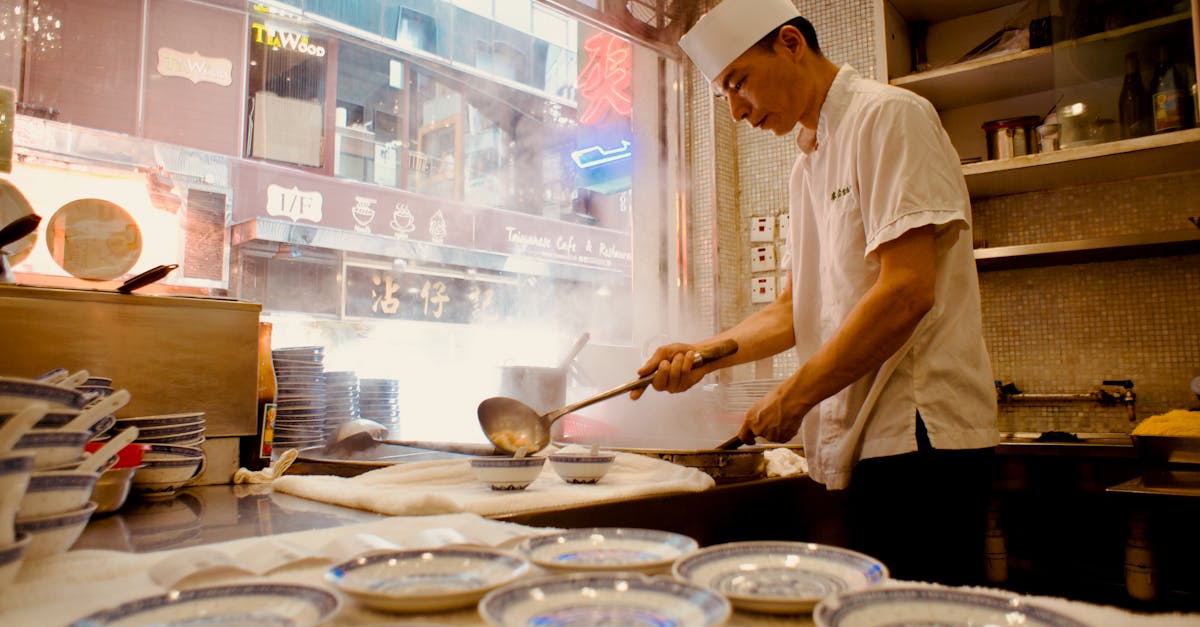 Asian chef in white attire cooking in a bustling Hong Kong restaurant kitchen with steam rising.