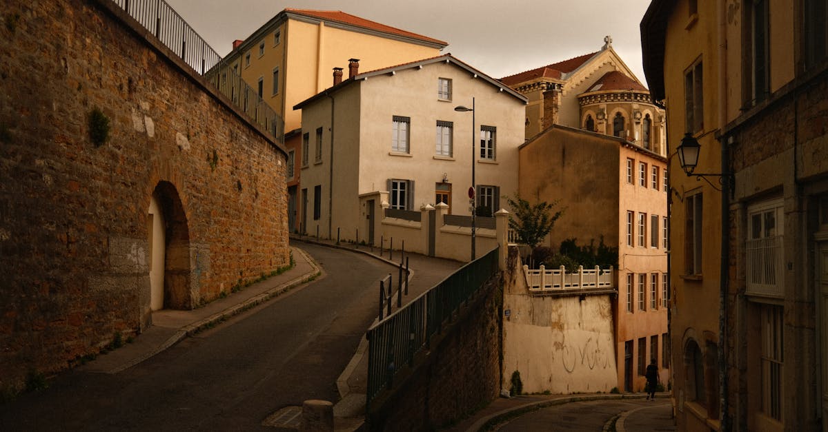 A picturesque winding street with classic European architecture at dusk, exuding historic charm.