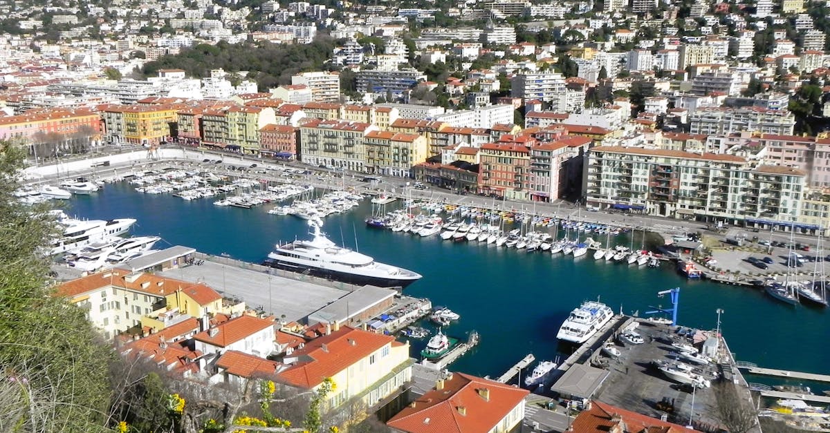 Scenic aerial view of Port Lympia in Nice, showcasing boats and colorful buildings along the harbor.