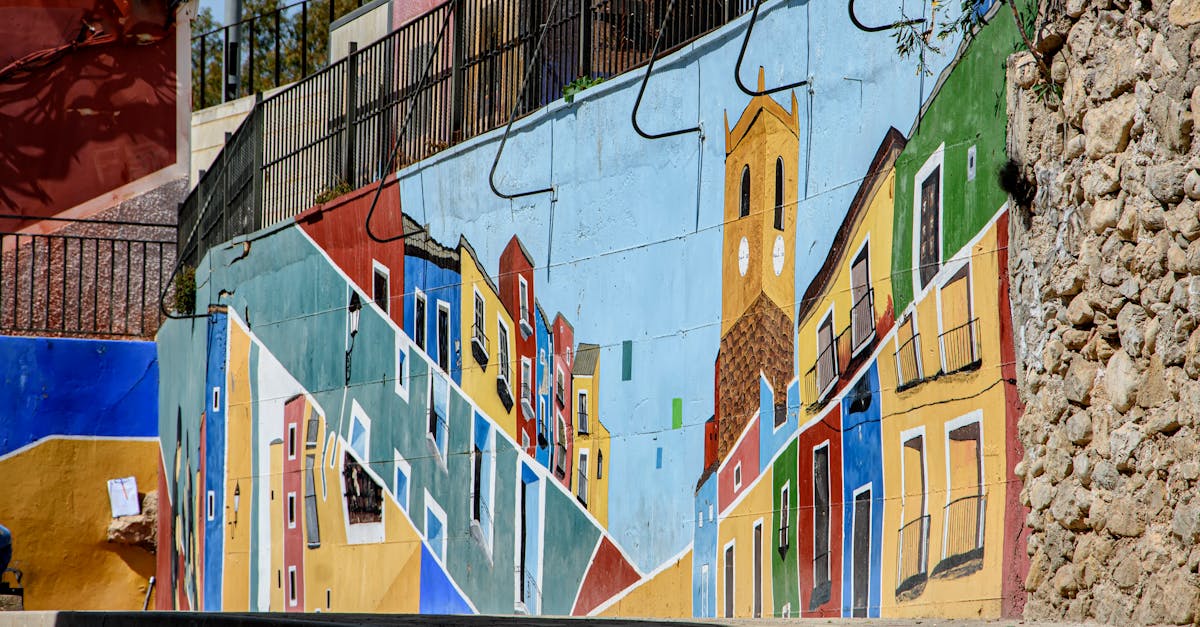 Vibrant street art mural depicting colorful buildings in Villajoyosa, Spain.