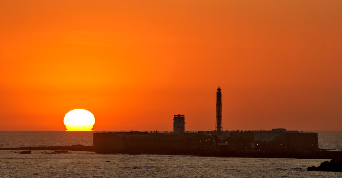 A captivating sunset over a coastal fortress with a lighthouse.