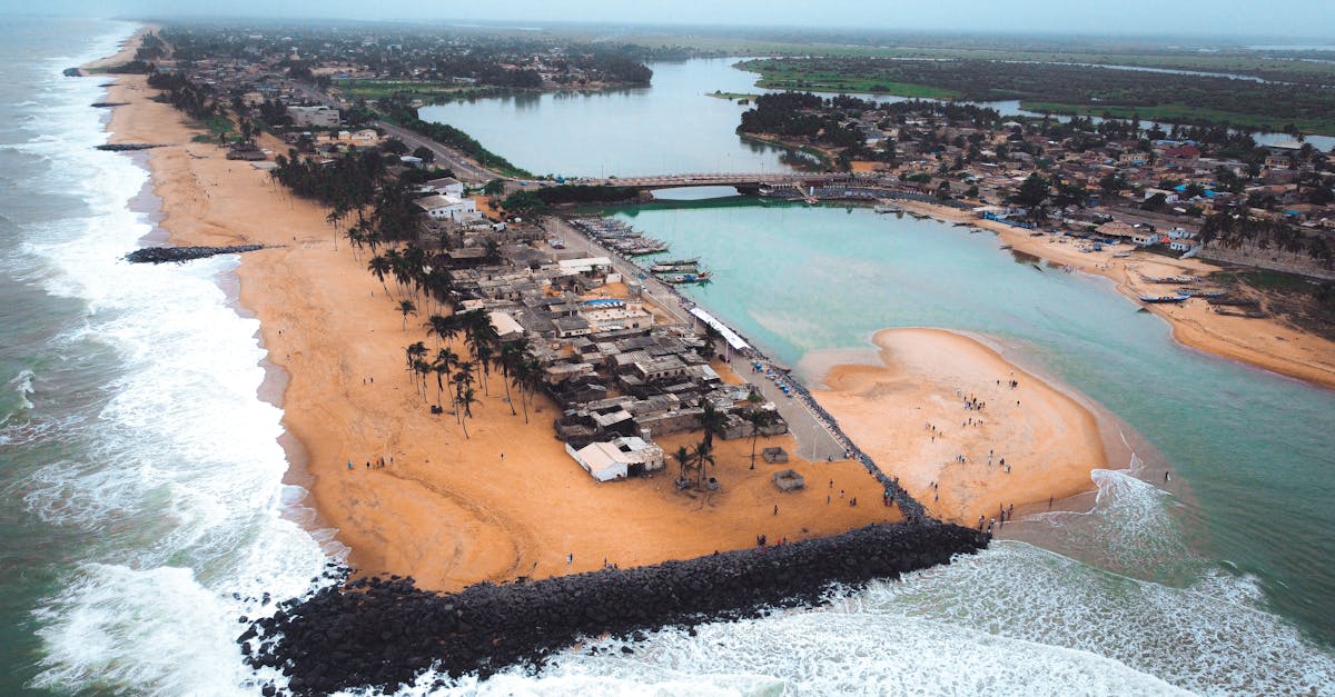 Scenic aerial view of a coastal town featuring a sandy beach and a river delta.
