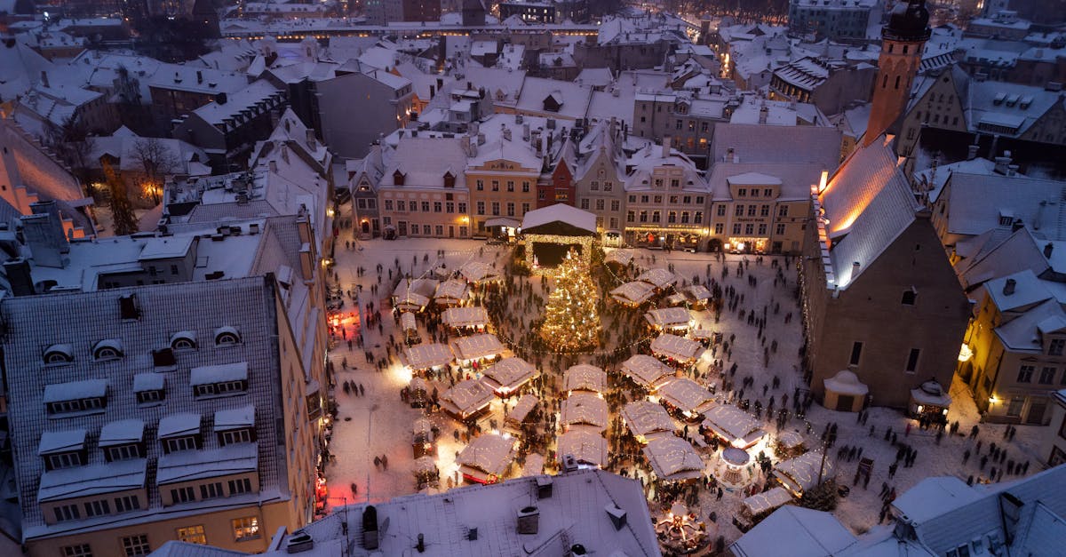 Magical winter evening at Tallinn's Christmas market with snow-covered roofs and festive lights.