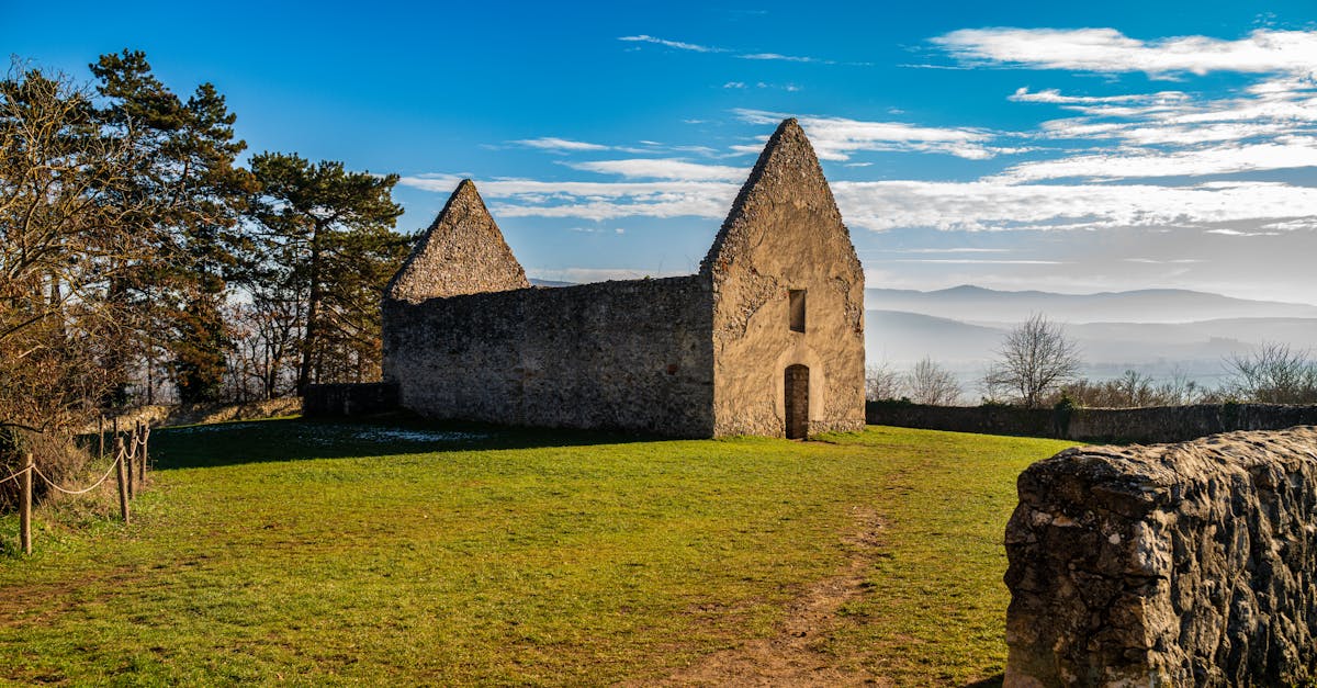 Ancient stone structure amidst green fields and blue sky, perfect for nature-inspired backgrounds.