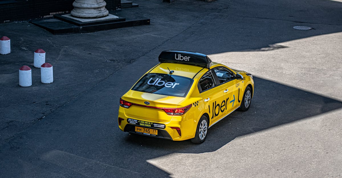 A yellow Uber taxi driving on a city street, shown from above.