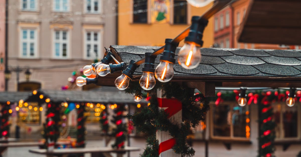 Charming Christmas market scene with warm glowing lights and festive decorations in an old town setting.