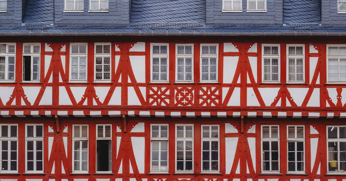 Close-up of a classic German half-timbered house exterior with red beams and white walls.