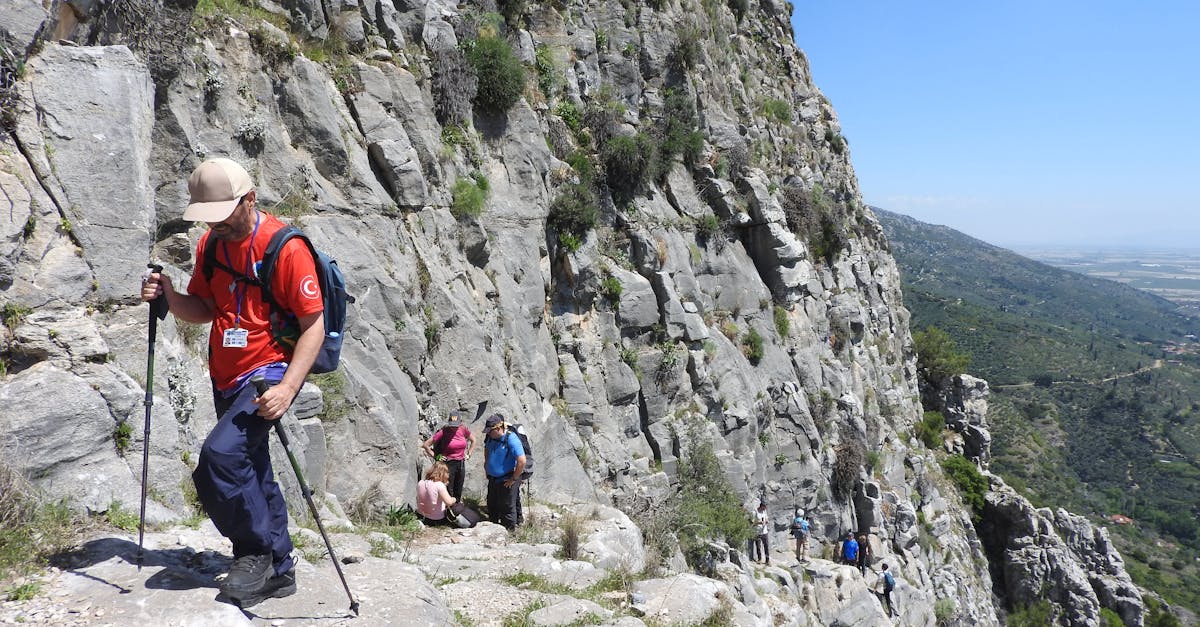 A group of hikers traversing a rugged mountain path during daytime, showcasing adventure.