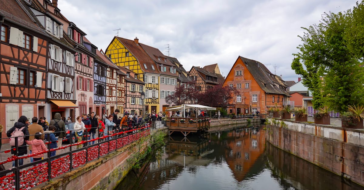 Picturesque canal scene in Colmar, France with vibrant medieval half-timbered buildings.