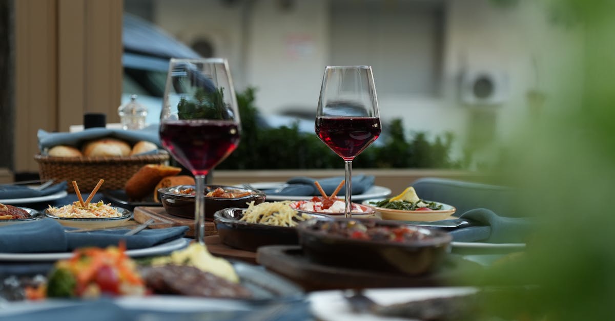 Luxurious outdoor table setting featuring red wine and a variety of gourmet dishes for a sophisticated dining experience.