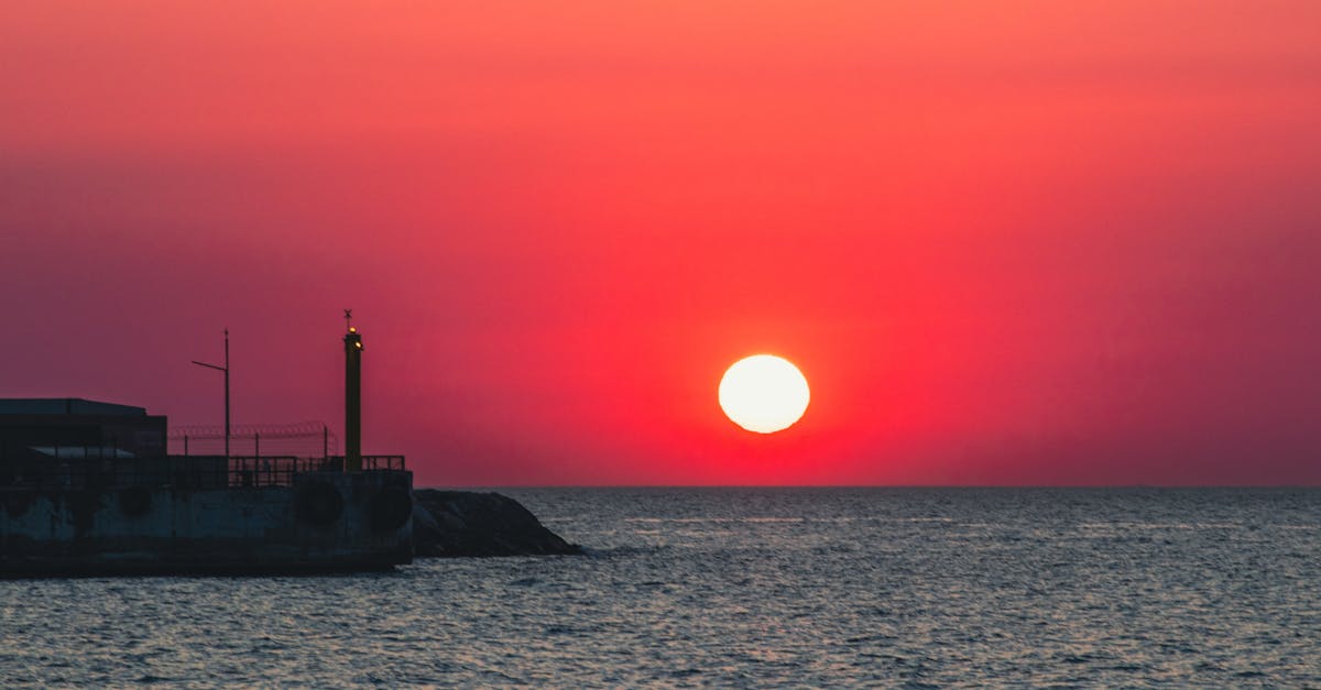 Stunning orange sunset casting glow over tranquil sea horizon.