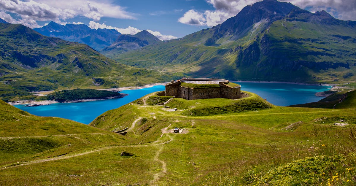 Breathtaking view of Mont-Cenis Fort surrounded by turquoise lake and the French Alps.
