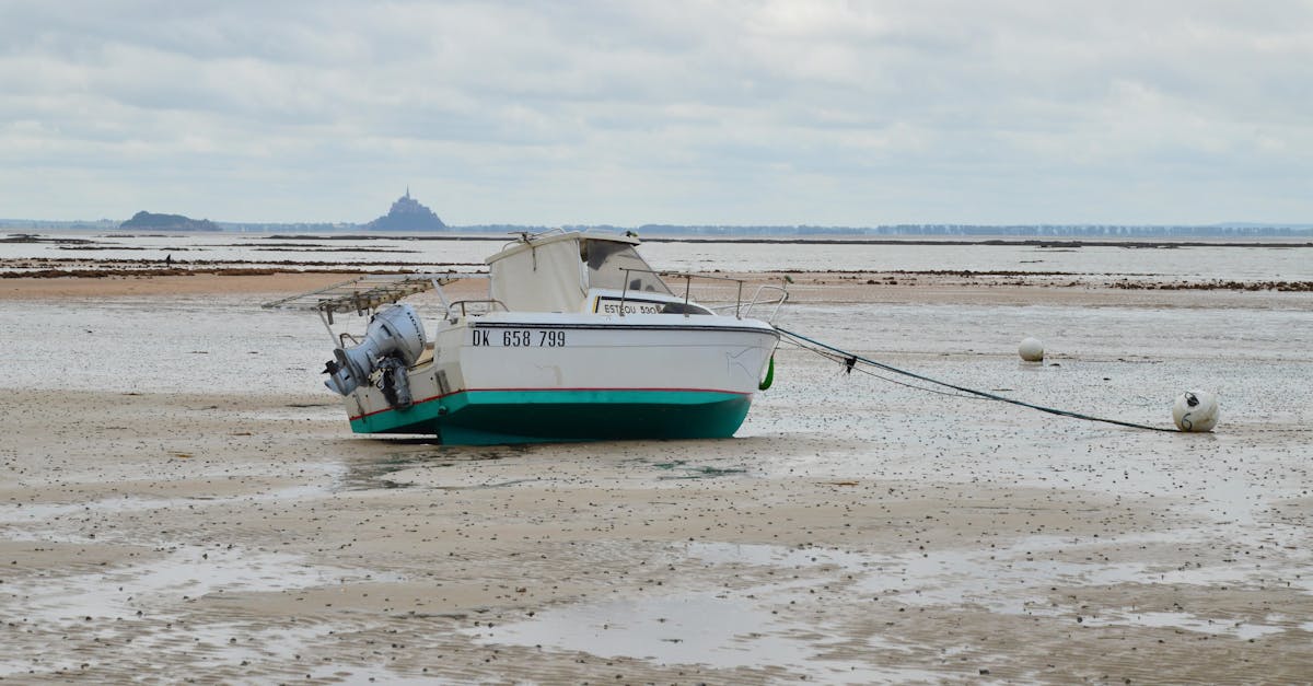 Beached boat at low tide with Mont Saint-Michel in the distance, captured in Normandie, France.