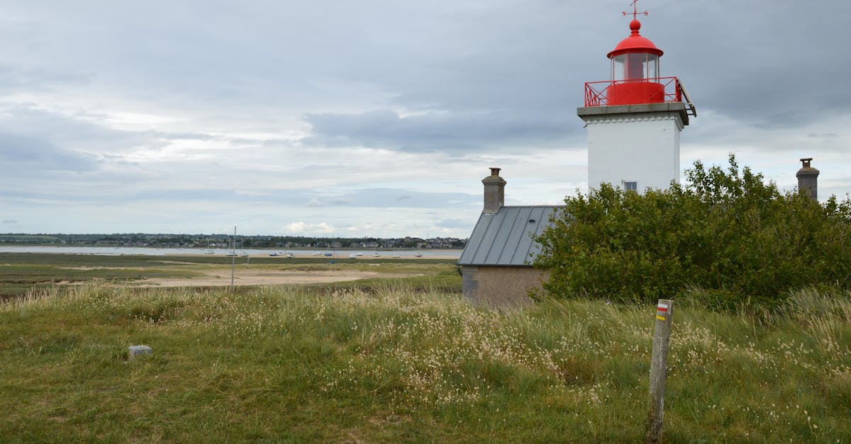 Lighthouse with red top in Agon-Coutainville, Normandy, France overlooking coast.