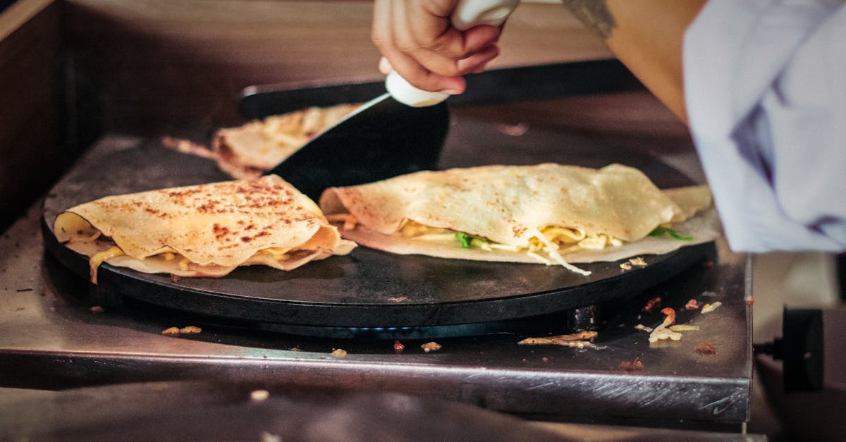Close-up of hands cooking crepes on a hot plate at a Brazilian market. Perfect street food scene.