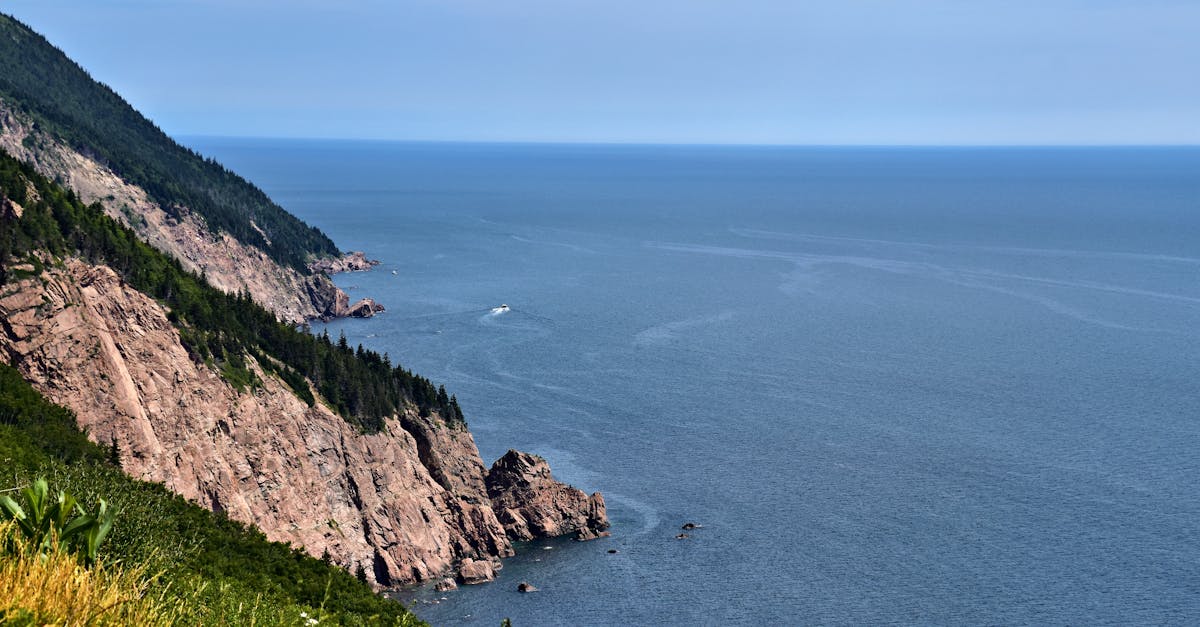 Explore the rugged coastal cliffs of Cape Breton, Nova Scotia with a view of the vast ocean.