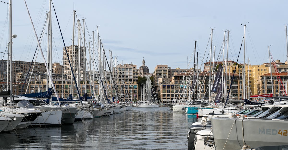 Stunning view of sailboats docked at the Old Port of Marseille with cityscape backdrop.
