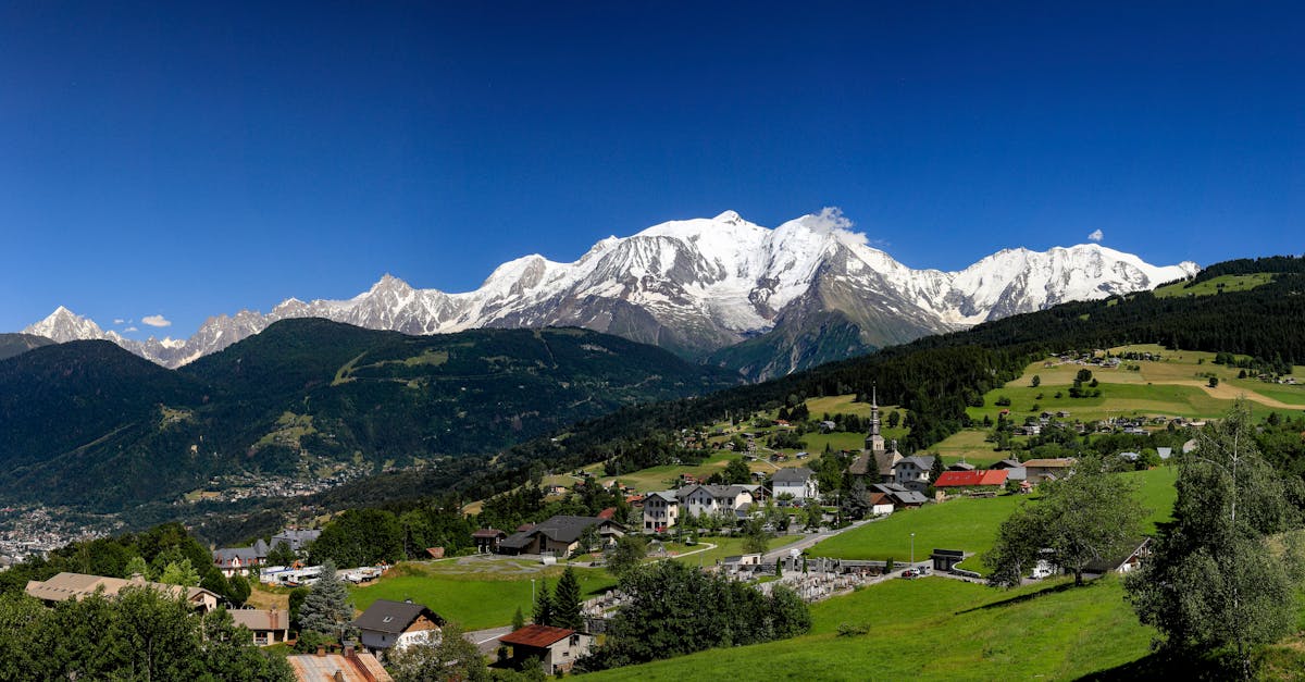 Panoramic view of Mont Blanc and a picturesque alpine village on a sunny day.