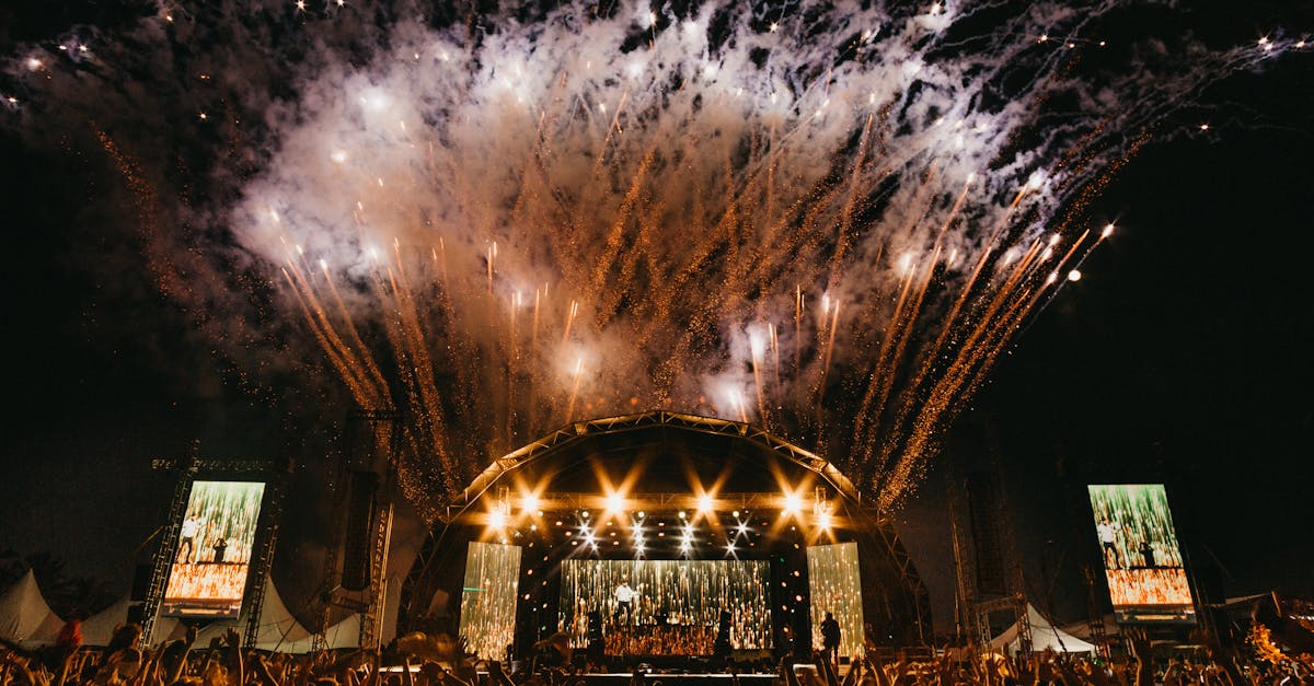 Energetic night concert with dazzling fireworks and a lively crowd outdoors.