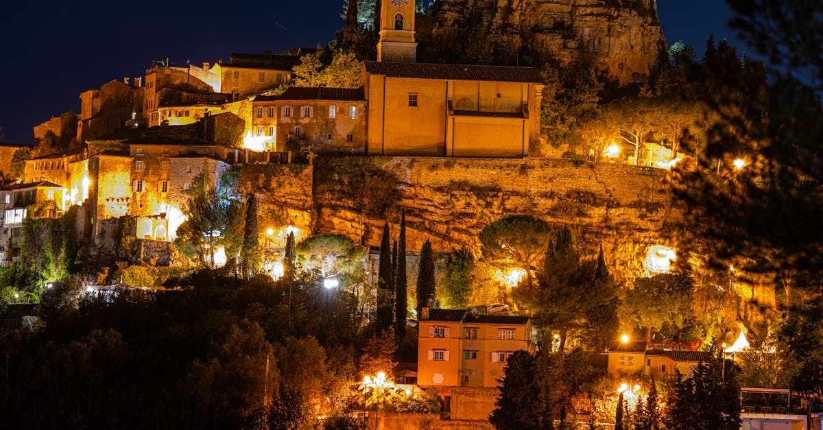 Beautiful night view of a hillside village with warm lights illuminating the architecture.