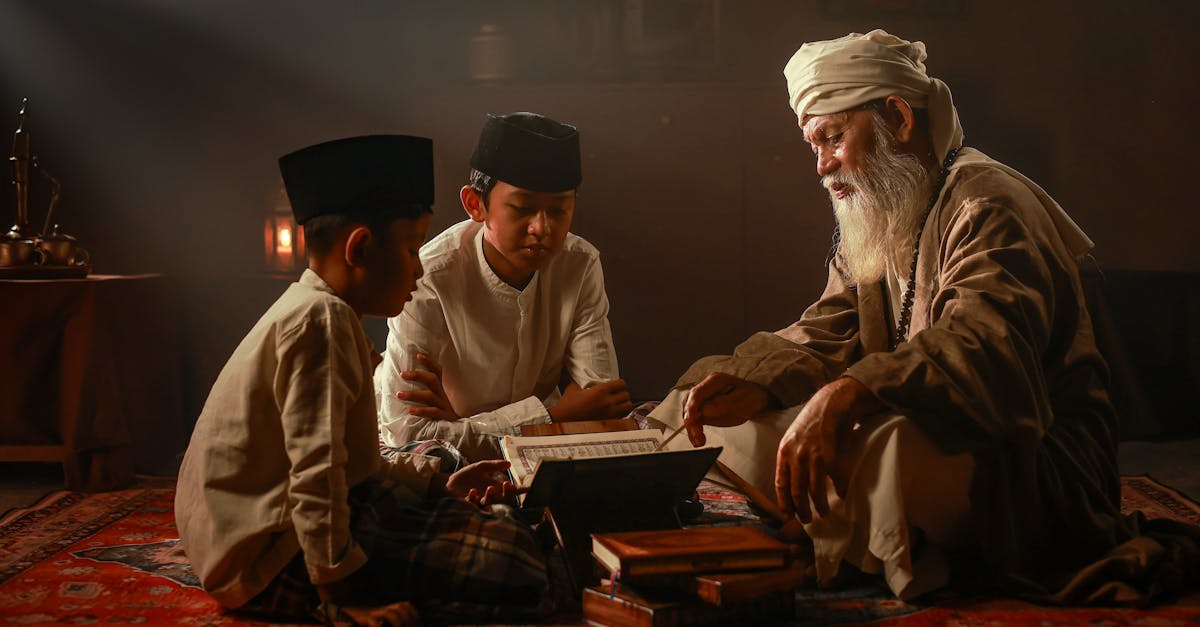 Elderly man teaching two boys in traditional Islamic attire indoors in Jakarta.