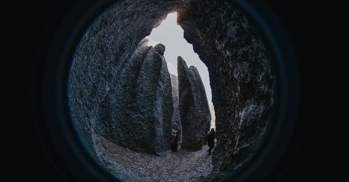 Fisheye view inside cave with people exploring towering rock formations at day