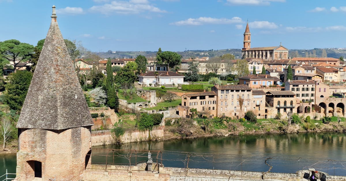 Charming riverside town in France with historical architecture and a church tower.