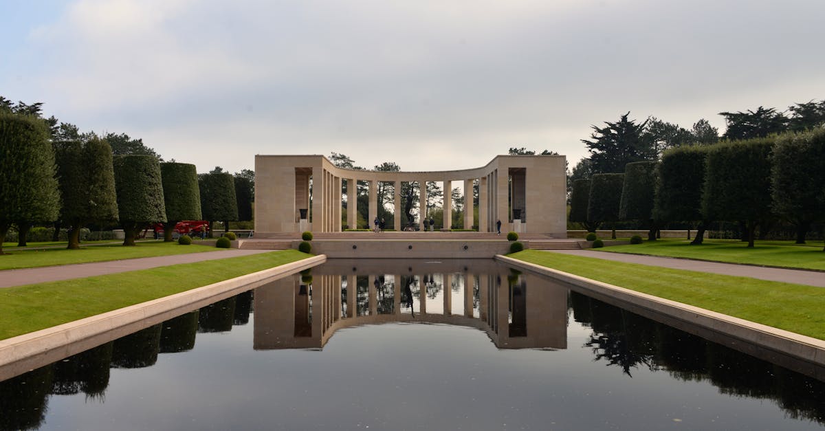 Calm and reflective atmosphere at Normandy American Cemetery Memorial with water feature and manicured gardens.